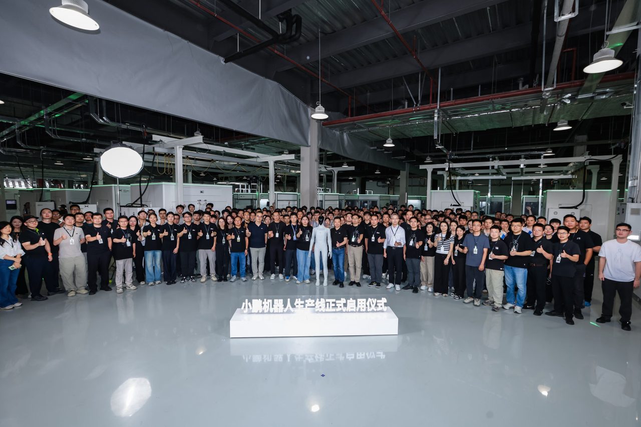 XPeng staff at the launch ceremony of the IRON humanoid production line with an IRON robot in the center